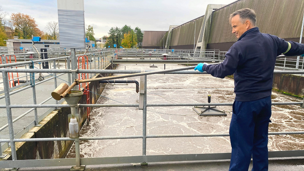 Hier wird eine Probe aus dem Becken der biologischen Reinigung entnommen.